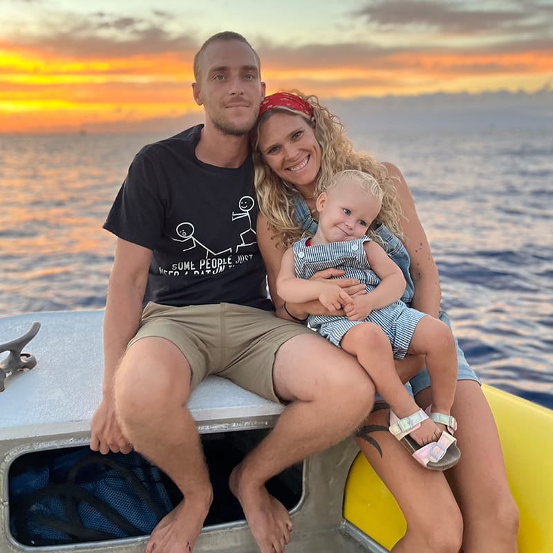 The family who own and run Go Whale Watching Maui, aboard their boat at sunset with their young daughter